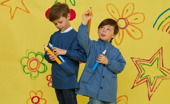 Deux garçons en blouses bleues avec des crayons