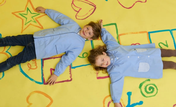 Deux enfants en blouses bleues allongés sur le sol