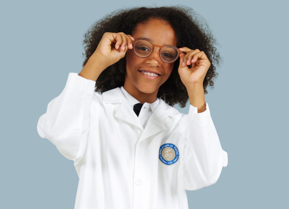 Élève en blouse de chimie blanche brodée au logo de son école