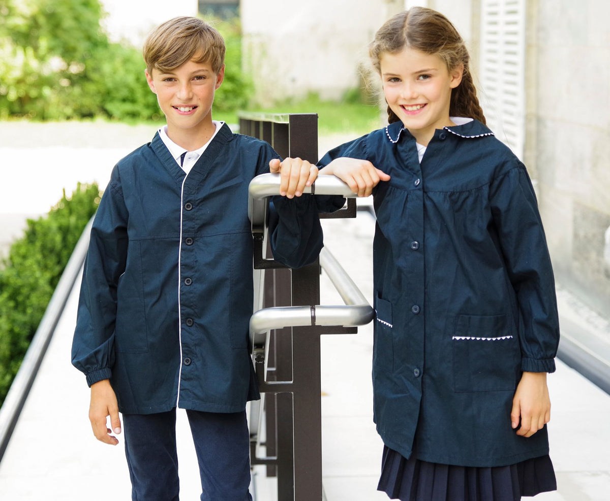 Garçon et fille en tabliers d'école bleu marine