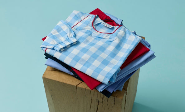 Pile de tabliers d'école pliés, vichy bleu et uni rouge